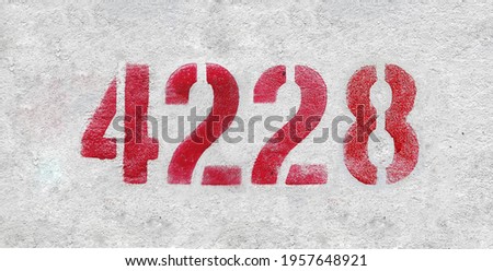 Red Number 4228 on the white wall. Spray paint.