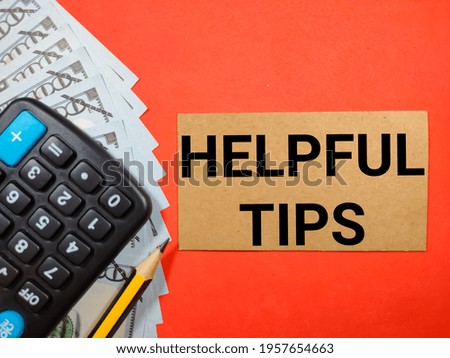 Text HELPFUL TIPS on red background with pencil,calculator and banknote.Business concept.
