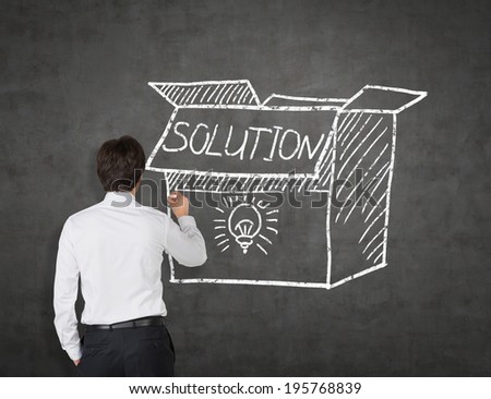 Businessman drawing a solution box. Grey background.