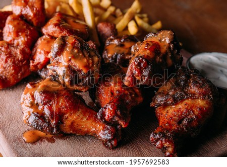 Buffalo Wing with sauce in wood table top Royalty-Free Stock Photo #1957692583