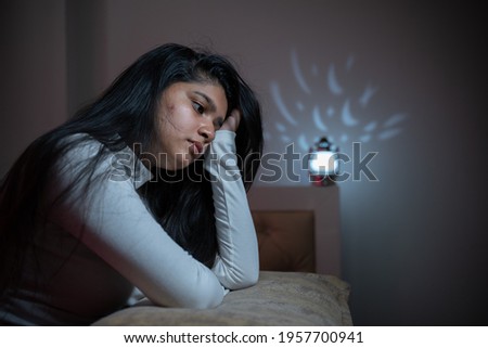 Worried young girl woke up during night on bed due to sleeplessness - Concept of insomnia,sleeping disorder, depression or PTSD or post-traumatic stress Royalty-Free Stock Photo #1957700941