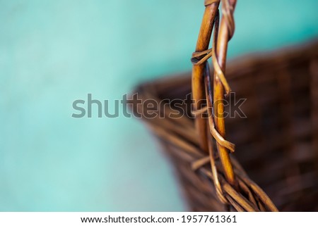 Yellow brown wicker square basket with handle in the studio. Light background. Macro. Place for text