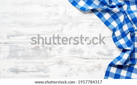 White wooden table covered with blue tablecloth. View from top. Empty tablecloth for product montage. Free space for your text