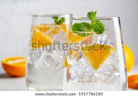 Hard seltzer cocktail with orange, mint and ice. Royalty-Free Stock Photo #1957786180