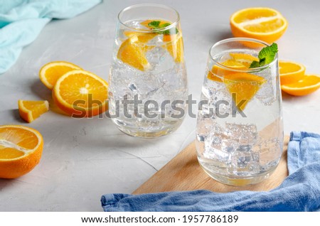 Hard seltzer cocktail with orange, mint and ice.