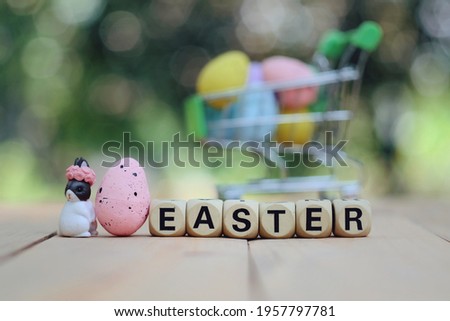 close up wooden text block, toy bunny and pink egg on table, hello spring season and holiday sale business, happy easter day concept