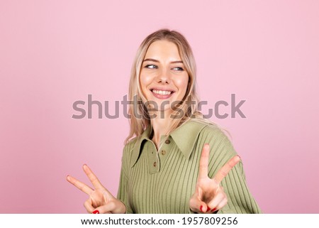 Pretty european woman in casual sweater on pink background smile to camera do peaceful gesture victory sign