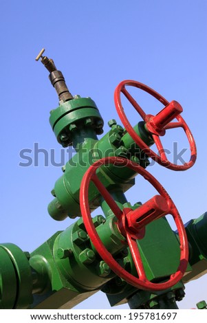 green petroleum machinery and red handwheel, closeup of photo