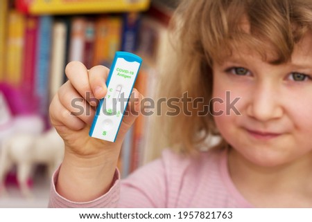Child holds a negative corona antigen test in hand  Royalty-Free Stock Photo #1957821763