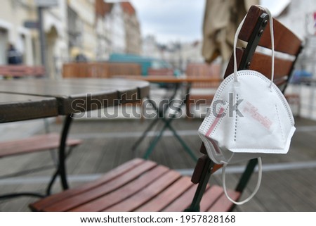 Corona crisis - lockdown - FFP2 mask hangs on a chair in an empty beer garden in Steyr, Austria, Europe Royalty-Free Stock Photo #1957828168