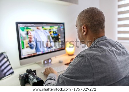 Work in an agency. Work from home as a freelancer. Editing and correction of photos in the living room in the apartment in casual clothes. Photographer and graphic designer