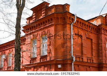 Orange red brick wall of an old building corner and huge windows. Architecture . Architect. History. Heritage. Design. Grunge urban. Industrial style. Orange brick wall