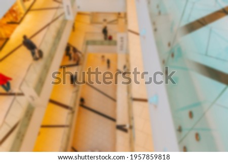 Shopping center blurred background. People shopping in modern commercial mall center. Interior of retail centre store in soft focus. Image for background use