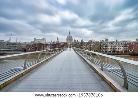 Millennium bridge and St Paul's cathedral with blurry dramatic sky