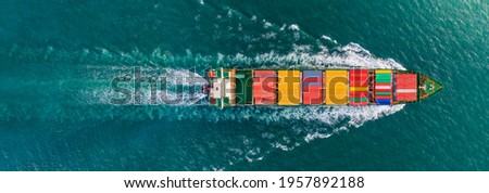 Aerial top view of cargo ship with contrail in the ocean sea ship carrying container and running for export from container international port to custom ocean concept freight shipping by ship service