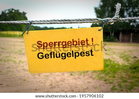 Sign at the entrance of a farm in Germany with the inscription restricted area avian influenza (Sperrgebiet Geflügelpest)   Royalty-Free Stock Photo #1957906102