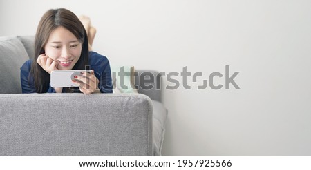 Young asian woman watching video with a smart phone.