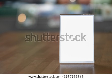 Mockup blank white screen advertising board or showcase billboard on table. Mock up billboard for your text messege or media content with blur department store or shopping mall