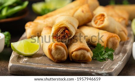 Fried vegetable spring rolls with sweet chili and soya sauce on wooden board Royalty-Free Stock Photo #1957946659