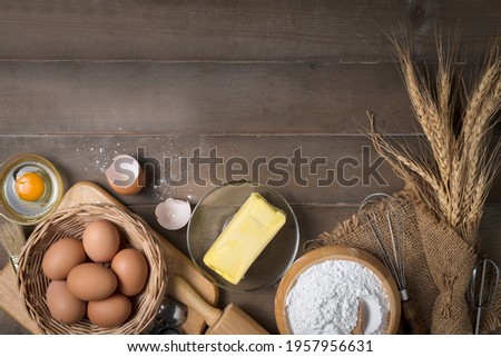Bread flour with fresh egg, Unsalted butter and accessories bakery on wood background, prepare for homemade bakery concept Royalty-Free Stock Photo #1957956631
