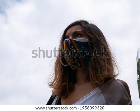 Young Hispanic Woman Wearing Doble Mask on a Cloudy Day