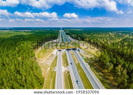 Expressway with ecoduct crossing - bridge over a motorway that allows wildlife to safely cross over the road, aerial top down view Royalty-Free Stock Photo #1958107096