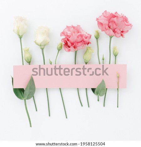 Square frame, Creative layout made of rose pink and white flowers and leaves with paper card note. Flat lay. Blank for advertising card or invitation. Flat lay. Nature concept.