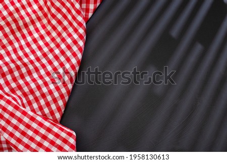 Dark rustic background with red checkered napkin - text space