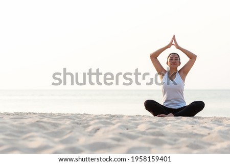 Lifestyle athletic woman yoga exercise and pose for healthy life.  Young girl or people pose balance body vital zen and meditation workout and fitness sport outdoor on sand beach. Health care Concept