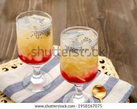 Es Blewah or contain slices of cantaloupe add with syrup, basil seed and ice. Good to drink for breakfasting Ramadan. Selective focus, wooden backgrond. Royalty-Free Stock Photo #1958167075