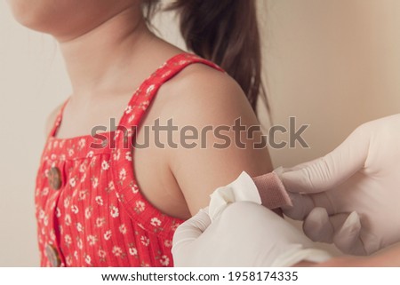 Young girl getting bandage on after got vaccinated or  inoculation, child immunization, covid delta vaccine