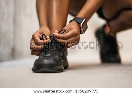 Athletic woman tying her shoelaces. Royalty-Free Stock Photo #1958209975