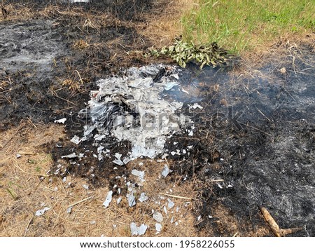 The burnt paper scraps on the grass