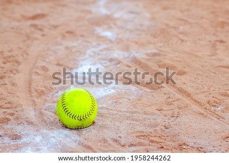 Old Softball in a softball field in California mountains on a white line