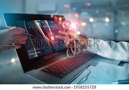 Medicine doctor team meeting and analysis. Diagnose checking osteoarthritis knee testing result with modern virtual interface on laptop, Joint ache problems, Medical technology network. Royalty-Free Stock Photo #1958255728
