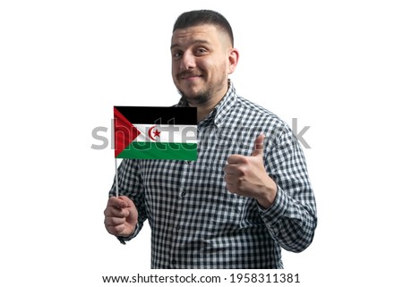 White guy holding a flag of Western Sahara and shows the class by hand isolated on a white background. Like for Western Sahara.
