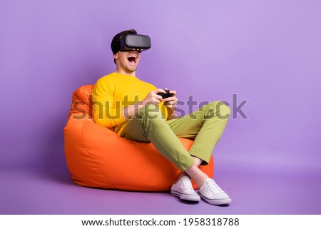 Full length profile photo of excited addicted gamer guy virtual reality gadget isolated on violet color background
