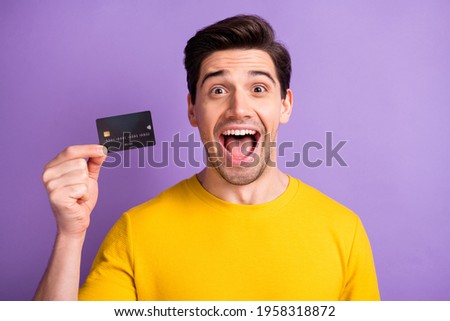 Photo of impressed handsome person hand hold debit card open mouth isolated on violet color background