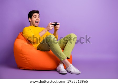 Full body profile portrait of crazy guy playing game open mouth look empty space isolated on purple color background
