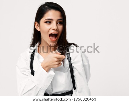 energetic woman in a white shirt gestures with her hands on a light background Copy Space