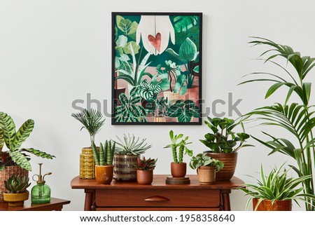 Domestic interior of living room with vintage retro shelf, a lot of house plants, cacti, wooden mock up poster frame on the white wall and elegant accessories at stylish home garden. Template. 