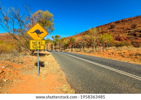 Kangaroo crossing sign warning drive along Northern Territory, Red Centre, Australia. Central Australian landscape. Larapinta drive to Alice Springs, Kinks Canyon, Glen Helen. Tourism in Red Centre.