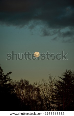 Full moon in horizon of dramatic night sky