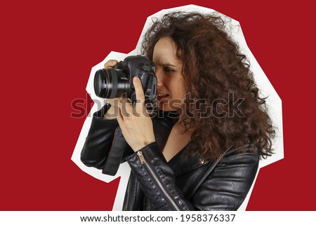 young girl photographer holds camera and looks at the viewfinder, magazine fashion style
