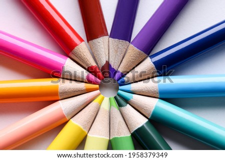 Multicolored pencils lying in shape of sun closeup