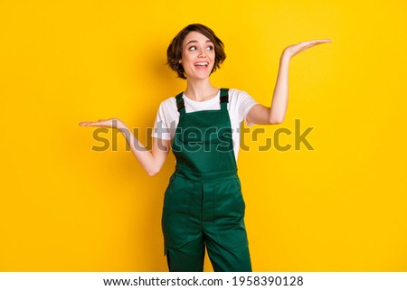 Photo of optimistic nice brown hair lady hold look empty space wear uniform isolated on yellow background