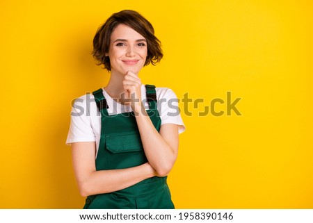 Photo of optimistic nice brown hair lady hand chin wear uniform isolated on yellow background