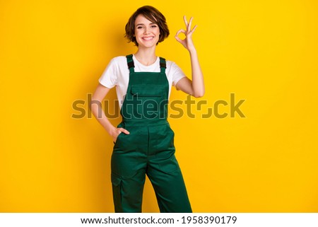Photo of optimistic nice brown hair lady show okey wear uniform isolated on bright yellow color background