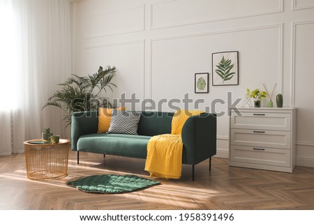 Stylish living room interior with comfortable green sofa Royalty-Free Stock Photo #1958391496
