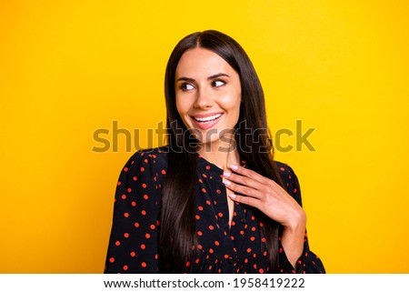 Photo of funny impressed young woman wear dotted outfit arm chest looking empty space isolated yellow color background
